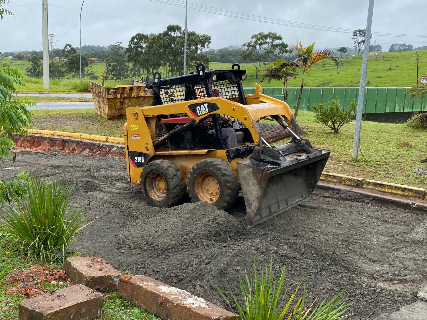 Mini carregadeira Caterpillar da Hloc espalhando brita em obra